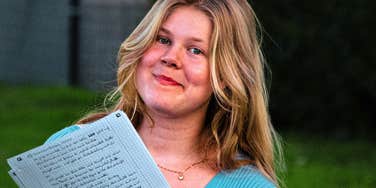 A woman with a list of items to cut from her budget, capturing the 'strategic frugality' needed to retire years ahead of schedule.