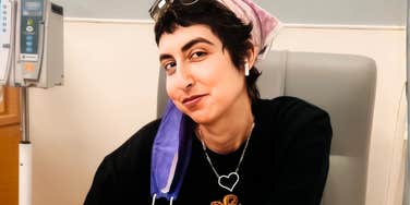 The author pictured in a chemo treatment chair; a visual starting point for a story about navigating a sudden cancer diagnosis as a healthy single mother.