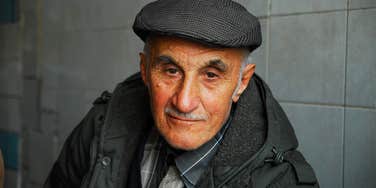 An elderly man in a flat cap looking serene and peaceful, illustrating the profound moment of acceptance when a terminal cancer diagnosis becomes a source of inner clarity.