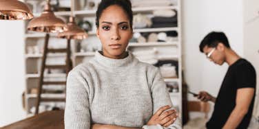 Transactional parent in her home with her teen son standing away from her 