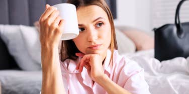 A young woman looking unhappy while getting ready at home; a visual representation of morning anxiety and the need for small, restorative routine changes.