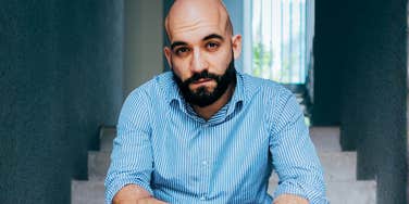 A man sitting alone on stairs, capturing the 'silent warning signs' and the psychological toll of a missed medical diagnosis before a major cardiac event.