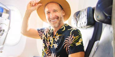 A handsome adult male passenger having great time on flight.