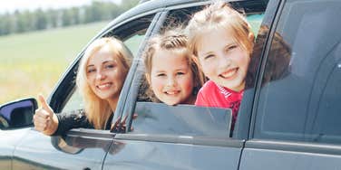 mom driving her kids in a black suv