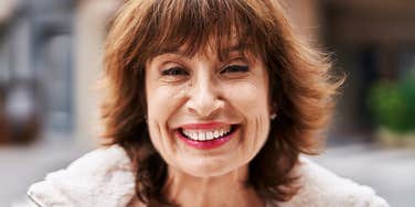 A portrait of a happy 78-year-old woman; a visual representation of the enduring nature of attraction and the wisdom shared in response to a young person's question about getting older.