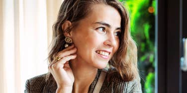 A stylish woman with an understated and humble demeanor; illustrating the subtle social behaviors and 'understated body language' people exhibit when they are strongly attracted to someone.