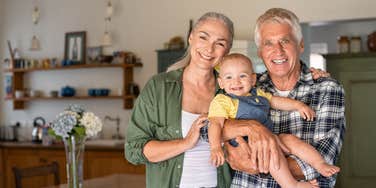 Boomer parents holding their grandchild 