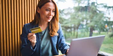 cheap woman holding her credit card refusing to overspend