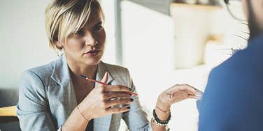 Smart and competent woman talking to a male colleague in a professional setting 
