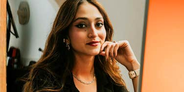 A portrait of a businesswoman looking poised and focused at her desk; illustrating the unapologetic 'me-first' mindset that allows high-performing individuals to maintain productivity without worrying about workplace approval.