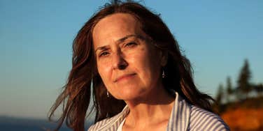 A portrait of an older woman looking calm and resolute in a natural outdoor setting; illustrating the personality type that finds retirement communities a 'nightmare' due to a deep-seated need for personal space