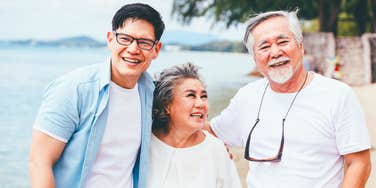 Great parents with their grown son smiling on a beach