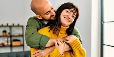 man hugging woman from behind nonverbally showing his love