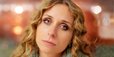 A reflective woman in soft focus lighting; illustrating the psychological impact of traditional social norms and the ongoing debate over what women should be legally required to do after marriage.