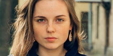 Young adult woman looking angry and serious at the camera 
