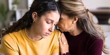 Older mom comforts her Gen Z young adult daughter 