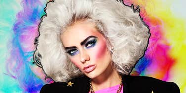 A young woman with giant, hairsprayed eighties curls and bold makeup; illustrating the era of 'frozen' hairstyles and the specific cultural nostalgia currently trending among Gen Z and Gen X.