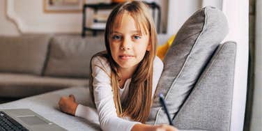 A smart young girl studying diligently with books and pens; illustrating the foundational life skills like discipline and problem-solving that are essential for a child's future success.