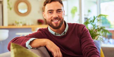 highly intelligent man sitting at home smiling