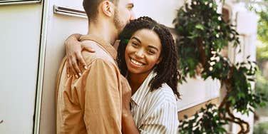 Young woman in a new relationship smiles while hugging a man 