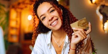 woman whose parents never taught her the value of money holding a credit card