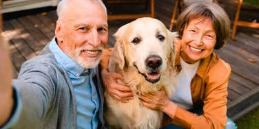 older couple who love their dog posing for a selfie