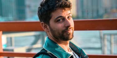 A portrait of a man casting a skeptical look over his shoulder while outdoors; illustrating the 'hyper-vigilance' and defensive mindset that can indicate underlying psychological struggles in men.