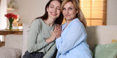 mom and adult daughter smiling