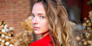 A woman with flowing, vibrant hair in a red outfit; illustrating the specific beauty archetypes within the LDS community and how hair serves as a marker for identity and social standing.
