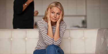 Older mom covering ears so she doesn't hear something at home