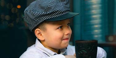 A portrait of a child in vintage-style clothing looking up with curiosity; illustrating the 'active listening' phase of childhood where the timeless wisdom and steady guidance of great parents create a lasting sense of security and respect.