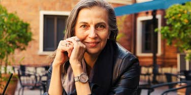 A portrait of a woman showing genuine engagement by leaning forward in a conversation; illustrating the non-verbal cues and consistent habits that define high-integrity people you can trust.