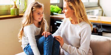 A portrait of a young child engaged in a serious conversation with their mom; illustrating the psychological concept of 'emotional incest' or role reversal where a parent uses a child as a primary emotional confidant.
