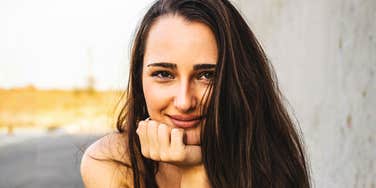 A portrait of a self-assured woman with a steady and relaxed gaze; illustrating the inner peace and 'secure' mindset that leads to the use of specific, high-value phrases in daily life.