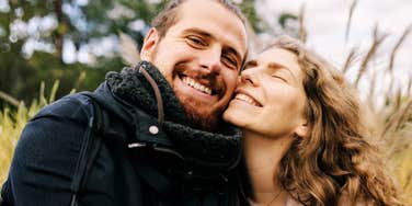 A joyful man and woman looking at each other with genuine affection and ease; illustrating the rare signs of a deep, secure attachment that most people strive to find in a partner.