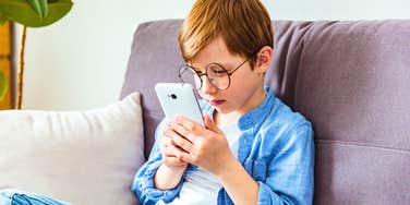 young boy using ai on his parents' phone