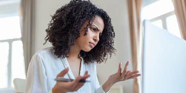 woman confused looking at laptop screen