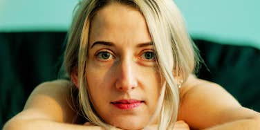 A portrait of a pensive woman resting at a table; illustrating the moment of reflection needed to overcome chronic second-guessing and rebuild self-trust through small behavioral changes.