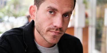 Man who is deeply lonely but keeping to himself looking at camera
