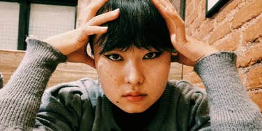 A portrait of a person; illustrating the internal struggle of adult ADHD where constant digital distractions and wandering thoughts are reframed as neurological traits rather than character defects.