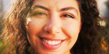 A young mixed-race model posing outdoors with a confident and joyful expression; illustrating the 'mindset mastery' and internal resilience that strong-minded individuals cultivate through daily repetition.