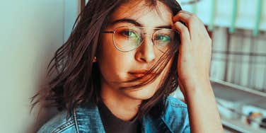 A portrait of an intelligent-looking woman in glasses; illustrating the 'unconscious competence' and ease of focus that characterize individuals with superior neural connectivity and pattern recognition skills.