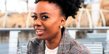 A woman looking away with a distracted and skeptical expression; illustrating the 'mental load' of focusing on gossip, vanity, or other low-value stimuli that often signal a lack of intellectual discipline.