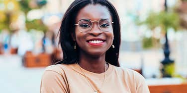 high-value woman smiling confidently outside