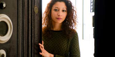 serious woman welcoming guests into her home