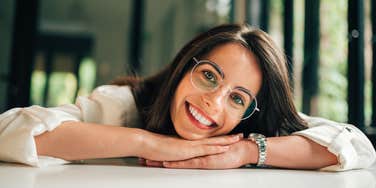 very smart woman smiling laying on a table at home