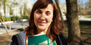 A vibrant woman in her early 50s with a funny and happy expression; illustrating the 'unretirement' trend where older professionals embrace new beginnings and the courage to be a beginner in a modern workplace.