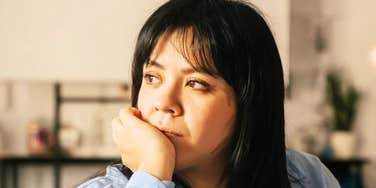 A mature woman in her 40s looking contemplative outdoors; illustrating the specific emotional and social challenges, such as 'dating fatigue' and high standards, that women in this demographic frequently face.