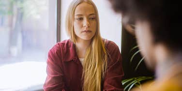 sad woman having a conversation with a friend in public