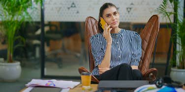 young employee talking on phone and sitting at desk